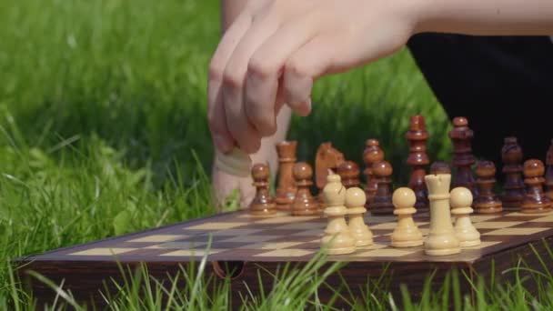 Niño se prepara para el juego de ajedrez y poner las figuras en el tablero de ajedrez — Vídeo de stock