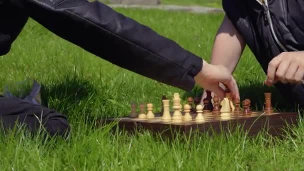 Zwei Teenager spielen Schach auf Rasen im Park — Stockvideo