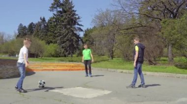 Üç erkek oyunları Futbol Park, dördüncü çocuğu tekme üzerinde sürme