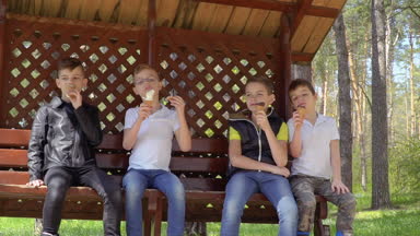 Dört kardeş yiyor çardak Park içinde dondurma rahatlatıcı