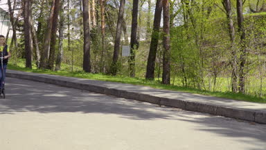 Çok güzel çocuk Park tekme scooter üzerinde çiçekler eller ve sürme tutar