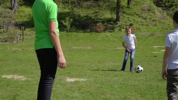 Τρία αδέλφια παίζουν ποδόσφαιρο στο πάρκο καλοκαίρι — Αρχείο Βίντεο
