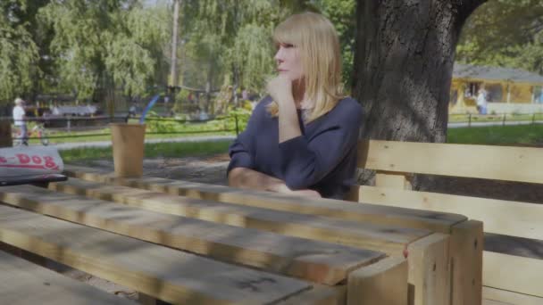 Schöne erwachsene Frau entspannen im Park und trinken Kaffee — Stockvideo