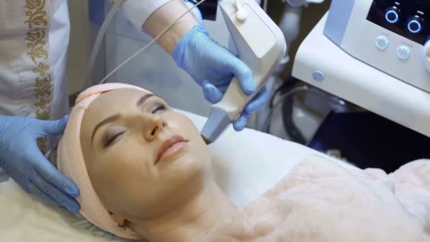 Terapeuta faz procedimento de levantamento de rf da pele facial — Vídeo de Stock