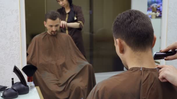 Parrucchiere taglia i capelli dell'uomo con rasoio elettrico — Video Stock