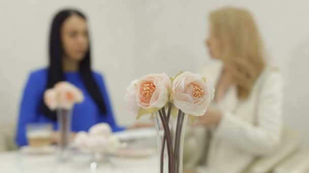 Bouquet of peonies at blurred business meeting background — Stock Video