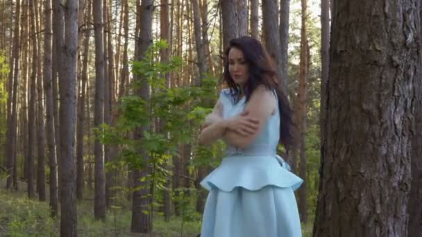 Hermosa mujer en vestido azul ola de insectos en el bosque — Vídeos de Stock