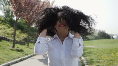 Genç güzel kadın yürümek yavaş çiçek açan Park