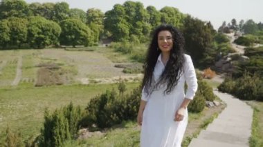 Beyaz elbiseli güzel gülümseyen esmer merdivenlerden yukarı hareket ediyor
