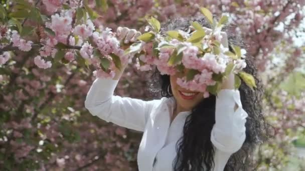 Güzel bir kadın çiçek açan dalı bırak ve goes uzağa, ağır çekim — Stok video