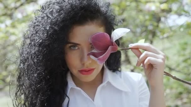 Beautiful woman enjoy smell of magnolia flower — Stock Video