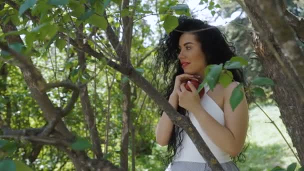 Mujer elegante con manzana roja en el jardín — Vídeo de stock