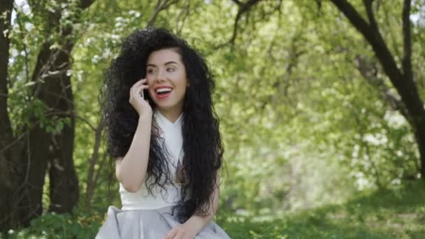 Hermosa mujer hablar por teléfono en el jardín verde — Vídeo de stock