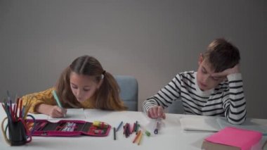 Masaya kalem atan beyaz bir çocuğun portresi. Onun çalışkan bayan sınıf arkadaşı şaşırtıcı bir şekilde ona bakıyor. Eğitime farklı tutum, kötü ve iyi davranış.