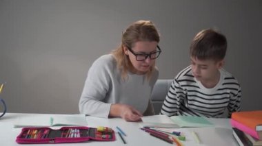 Güzel beyaz kadın öğretmen öğrencisiyle konuşuyor. Zeki öğrenciye beş veren bir kadın. Eğitim konsepti, ilkokul, ev eğitimi.