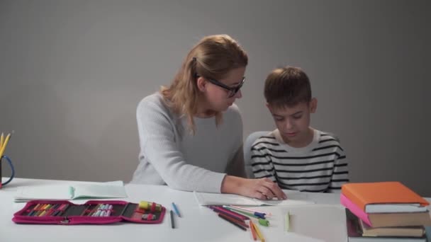 Kleine blanke jongen praat met zijn slimme moeder. Mooie vrouw knuffelt haar zoon en geeft hem vijf. Onderwijs concept, basisschool, thuisonderwijs. — Stockvideo