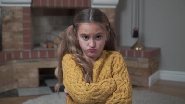 Close-up gezicht van een boos blank meisje in mosterd trui met gekruiste handen op de borst. Ontevreden kind schudt het hoofd zonder gebaar. — Stockvideo