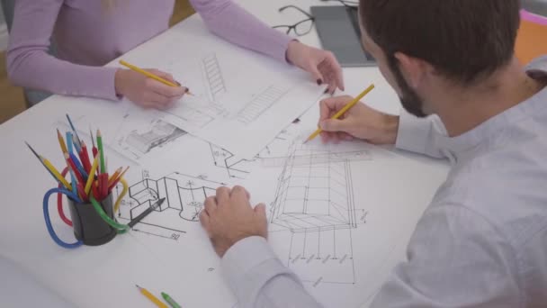 Ovanifrån av kvinnliga kaukasiska händer visar ritning till kollegan. Professionella designers diskuterar projekt och fastställande av ritningar. Två unga arkitekter som arbetar på kontoret. — Stockvideo