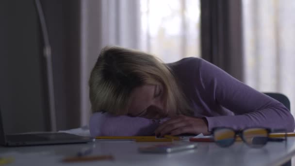 Ofisteki masada uyuyan yorgun beyaz bir kadın. Genç, yorgun, profesyonel mimar ya da tasarımcı geceyi işte geçiriyor. Aşırı çalışma, aşırı yüklenme, çalışkanlık. — Stok video