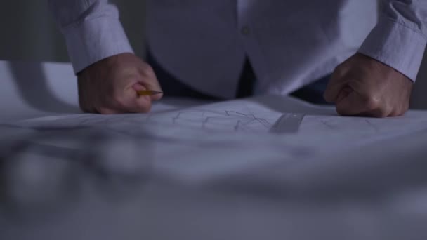 Gros plan des poings masculins caucasiens mis en colère sur les dessins architecturaux couchés sur la table. Architecte adulte jetant crayon insatisfait de son travail. Problèmes liés à la mise en œuvre du projet . — Video