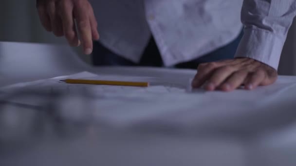 Primo piano delle mani caucasiche maschili che prendono matita e righello e iniziano a disegnare il progetto. Architetto adulto nel processo del suo lavoro. Attuazione dell'idea di progettazione . — Video Stock