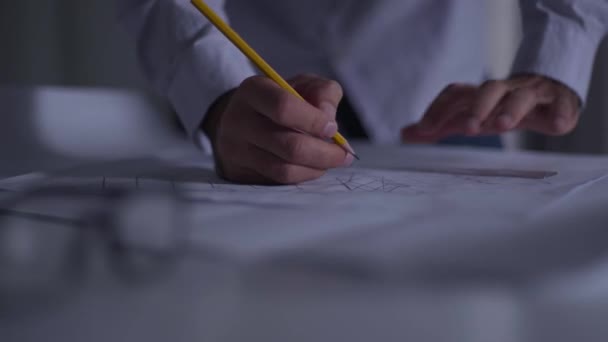 Primer plano de las manos masculinas escribiendo notas en el plano con el lápiz. Arquitecto caucásico adulto trabajando en el nuevo proyecto. Aplicación de la idea de diseño . — Vídeo de stock