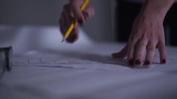 Gros plan des mains féminines caucasiennes avec une manucure rouge dessinant le plan et prenant des notes. Architecte adulte travaillant sur le nouveau projet. Professionnelle dans le cadre de son travail . — Video