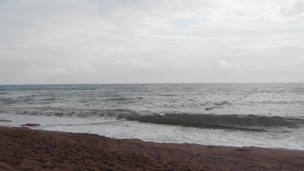 Kamera närmar sig kvällsvågor av Medelhavet kraschar på sandstranden. Vacker solnedgång i Turkiet. — Stockvideo