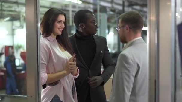 Jeune couple multiracial parlant avec le vendeur dans le showroom. Afro-Américain et belle femme caucasienne choisissant la voiture dans le concessionnaire. Famille Biracial acheter une voiture. Concessionnaire automobile, entreprise automobile .