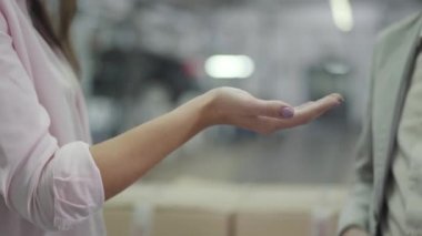 Beyaz bir erkeğin, tanınmayan bir kadın müşteriye araba anahtarı vermesi. Başarılı bir araba satıcısı genç bir bayana yeni otomobil satıyor. Araba bayiliği, araba işi..