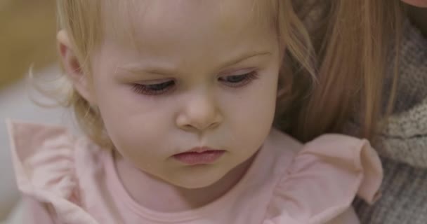 Extrémní detailní záběr smutné malé bělošky, jak se dívá dolů. Portrét roztomilého zachmuřeného dítěte s krásnýma šedýma očima a blond vlasy. Kino 4k záběry Prores Hq. — Stock video