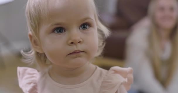 非常漂亮的白种人女婴的特写镜头，金发碧眼。 一个可爱的小孩的画像，他把目光移开，看着相机。 电影4k镜头Prores Hq. — 图库视频影像