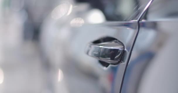 Gros plan de la poignée de porte de voiture noire ouverte par une main blanche masculine, un homme assis dans le salon et fermant la porte. Concessionnaire automobile, commerce automobile. Cinéma 4k séquences ProRes HQ . — Video