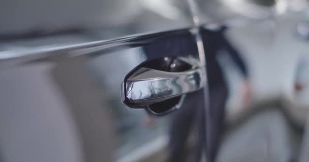 Close-up of car door handle opened by Caucasian bearded man reflecting in car side. Owner sitting into his vehicle. Car dealership, car business. Cinema 4k footage ProRes HQ. — Stock Video