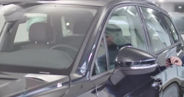 Homem caucasiano confiante com barba refletindo na superfície do carro como se aproximando do vechicle. Um adulto sentado no salão, a sorrir e a ligar o carro. Negócios de carros. Cinema 4k footage ProRes HQ . — Vídeo de Stock