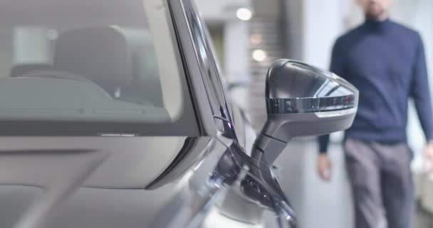 Un hombre caucásico con barba borrosa acercándose al coche negro y entrando en el salón. Propietario sentado en el automóvil en el estacionamiento. Negocios de autos. Cinema 4k metraje ProRes HQ . — Vídeos de Stock