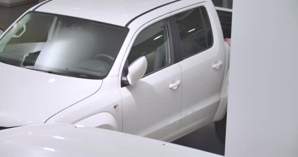 Vista superior del hombre caucásico barbudo examinando camioneta blanca en concesionario de automóviles. Comerciante masculino reflejándose en la superficie del coche. Exitoso hombre de negocios eligiendo el automóvil. Negocios de autos. Cinema 4k metraje ProRes HQ — Vídeos de Stock