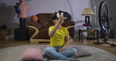 Beyaz erkek, VR kulaklık takıyor. Oyunu oynamak için uzaktan kumanda kullanıyor. Çocuk etrafına bakıyor ve gülümsüyor. Artırılmış gerçeklik, Vr Google. Sinema 4k Prores Merkezi.