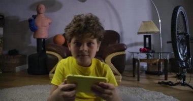 Kırmızı yorgun gözlü, beyaz tenli bir çocuk ekrana bakıyor ve akıllı telefon kullanıyor. Kafkas ergen çocuk oyun bağımlılığı yaşıyor. Teknolojiler, internet, video oyunları. Sinema 4k Prores Merkezi.