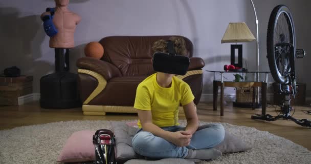 Portret van een jonge jongen met krullend haar die Vr googles draagt en praat. Leuke blanke schooljongen in geel T-shirt en blauwe jeans met augmented reality. Bioscoop 4k Prores Hq. — Stockvideo