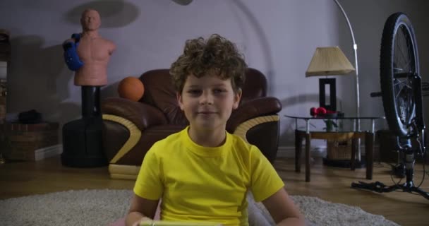 Moe Kaukasische jongen met krullend haar spelen videospelletjes thuis. Verslaafd kind dat de hele nacht speelt. Bioscoop 4k Prores Hq. — Stockvideo