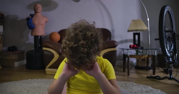 Cara de cerca de un chico caucásico exhausto bostezando y frotando los ojos. Niño con el pelo rizado jugando videojuegos en casa. Niño adicto jugando toda la noche. Adicción, generación Z. Cinema 4k ProRes HQ . — Vídeos de Stock