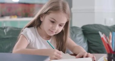 Evdeki masada ödev yapan beyaz bir çocuğun portresi. Matematik problemleri çözen düşünceli liseli kız. Eğitim, eğitim, öğrenme. Sinema 4k Prores Merkezi.