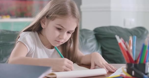 Close-up van het blanke meisje dat thuis wiskunde doet. Slim schoolmeisje doet huiswerk aan tafel. Onderwijs, studeren, leren. Bioscoop 4k Prores Hq. — Stockvideo