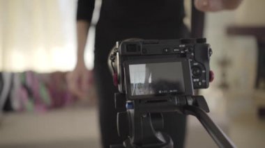 Beyaz kadının portresi çevrimiçi yayın başlatmak için kameradaki başlama düğmesine basıyor. Son sınıf blogcusu blogu için video kaydediyor. Teknolojiler, blog yazma, medya.