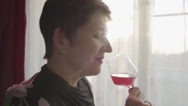 Side view close-up portrait of beautiful woman enjoying red wine in the evening. Elegant Caucasian brunette lady drinking from wineglass. Confident businesswoman resting after hard working day. — ストック動画