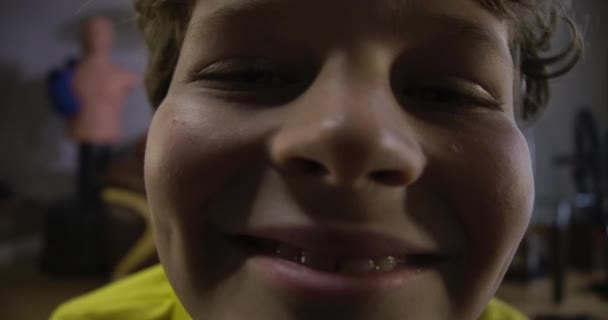 Extrema face close-up de menino caucasiano alegre com cabelo encaracolado olhando para a câmera e sorrindo. Retrato de um menino engraçado. Cinema 4k ProRes HQ . — Vídeo de Stock