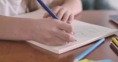 Çalışma kitabındaki matematik problemini çözen beyaz kadın ellerinin yakın çekimi. İlkokul öğrencisi ders alıyor. Eğitim, öğrenme, öğrenim kavramı. Sinema 4k Prores Merkezi.