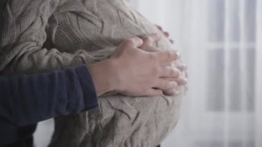 Hamile karnını okşayan beyaz erkek ve kadın ellerinin yakın çekimi. Genç bir aile, aile tazelemesi bekliyor. Hamilelik, gebelik, hamilelik.