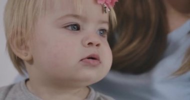 Kafkasyalı güzel bir kızın kurabiye çiğnemesinin yan görüntüsü. Gri gözlü ve sarı saçlı güzel bir çocuğun portresi. Sinema 4k Prores Merkezi.